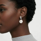 Woman wearing baroque pearl drop earrings with pave silver huggie | VAHN Jewels