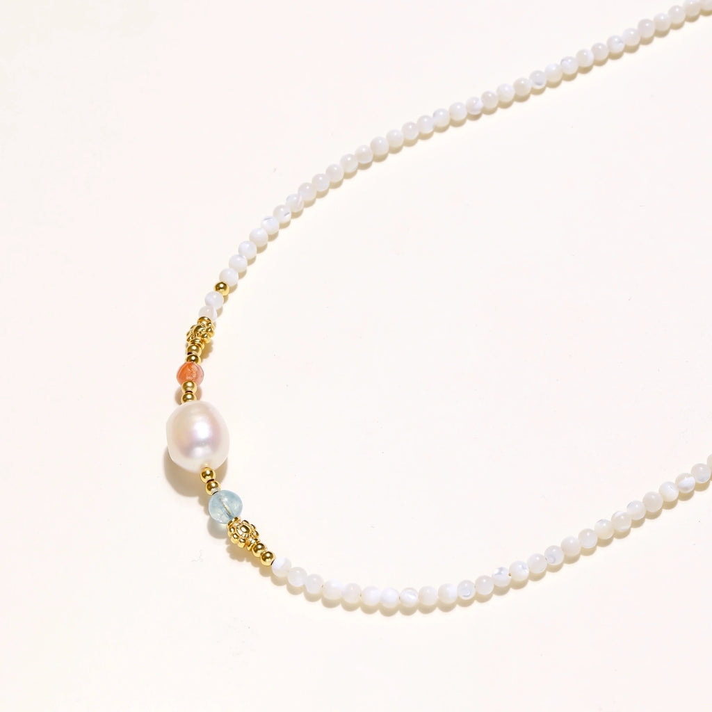 Detail view of baroque freshwater pearl and green gemstone accents with 18K gold vermeil on pearl garden necklace by VAHN Jewels