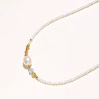 Detail view of baroque freshwater pearl and green gemstone accents with 18K gold vermeil on pearl garden necklace by VAHN Jewels