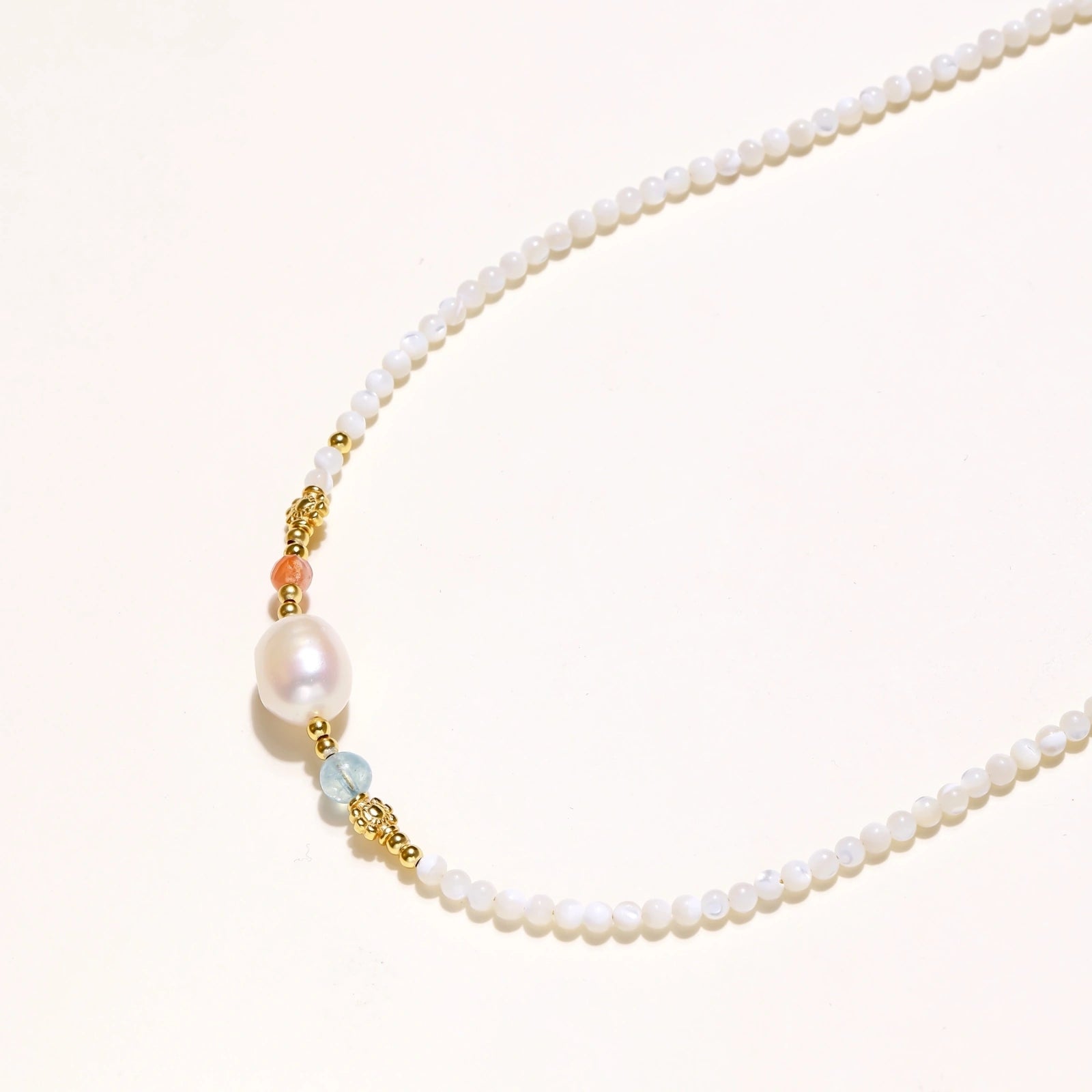 Detail view of baroque freshwater pearl and green gemstone accents with 18K gold vermeil on pearl garden necklace by VAHN Jewels