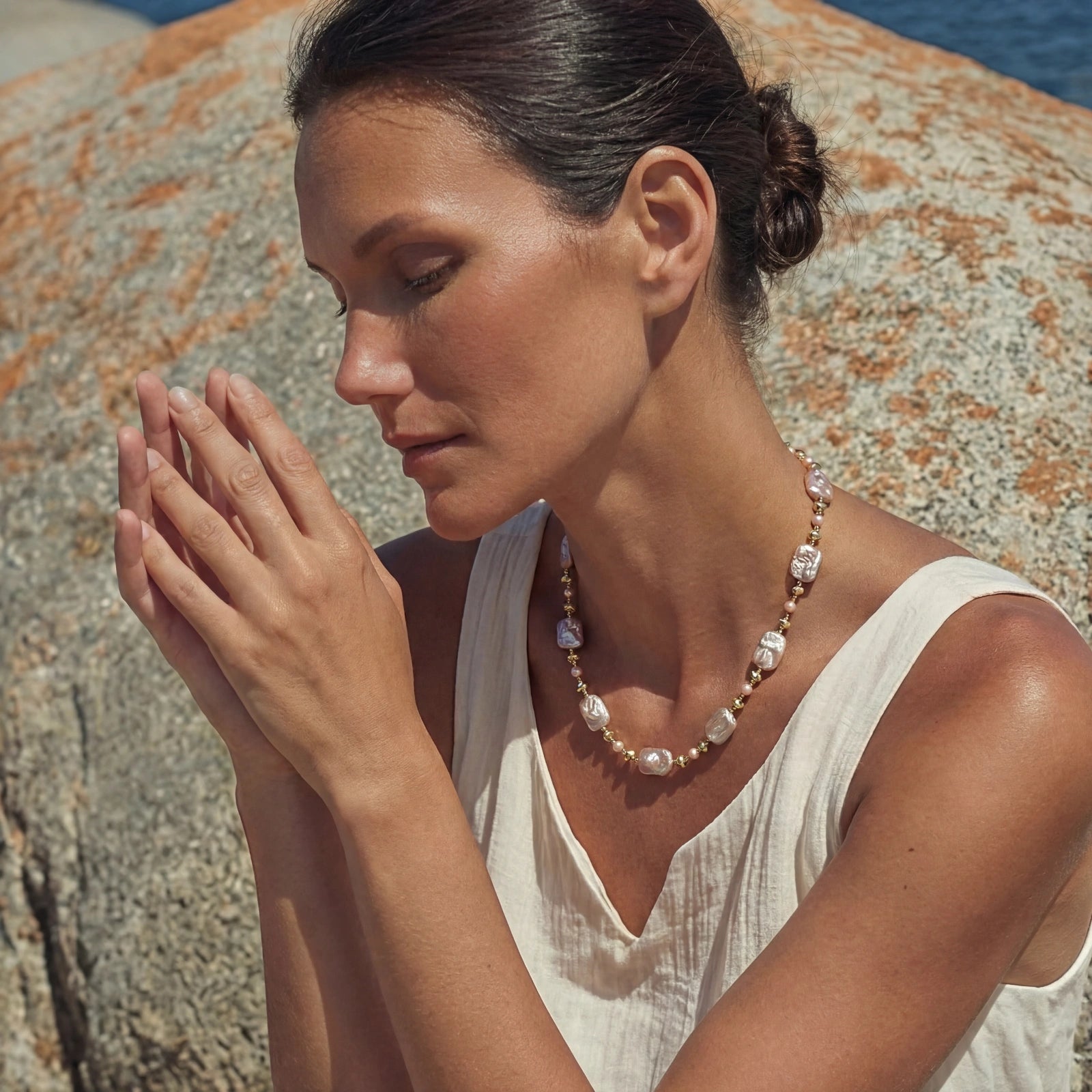 Woman wearing iridescent baroque pearl necklace on bare neckline VAHN Jewels
