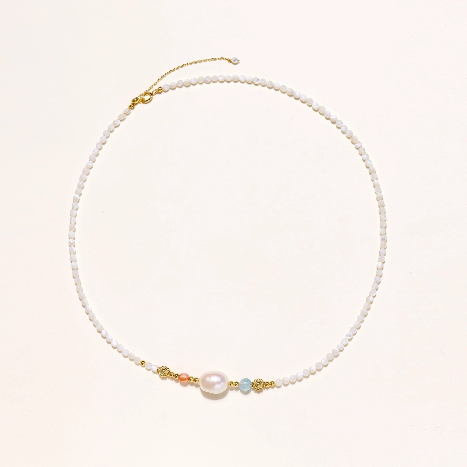 Flat lay of baroque pearl beaded vermeil necklace in 18K gold vermeil with faceted white beads