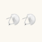 Angled view of brushed silver dome earrings showing matte texture and omega clip closure by VAHN Jewels