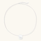 Brushed silver sphere necklace laid flat on ivory background VAHN Jewels