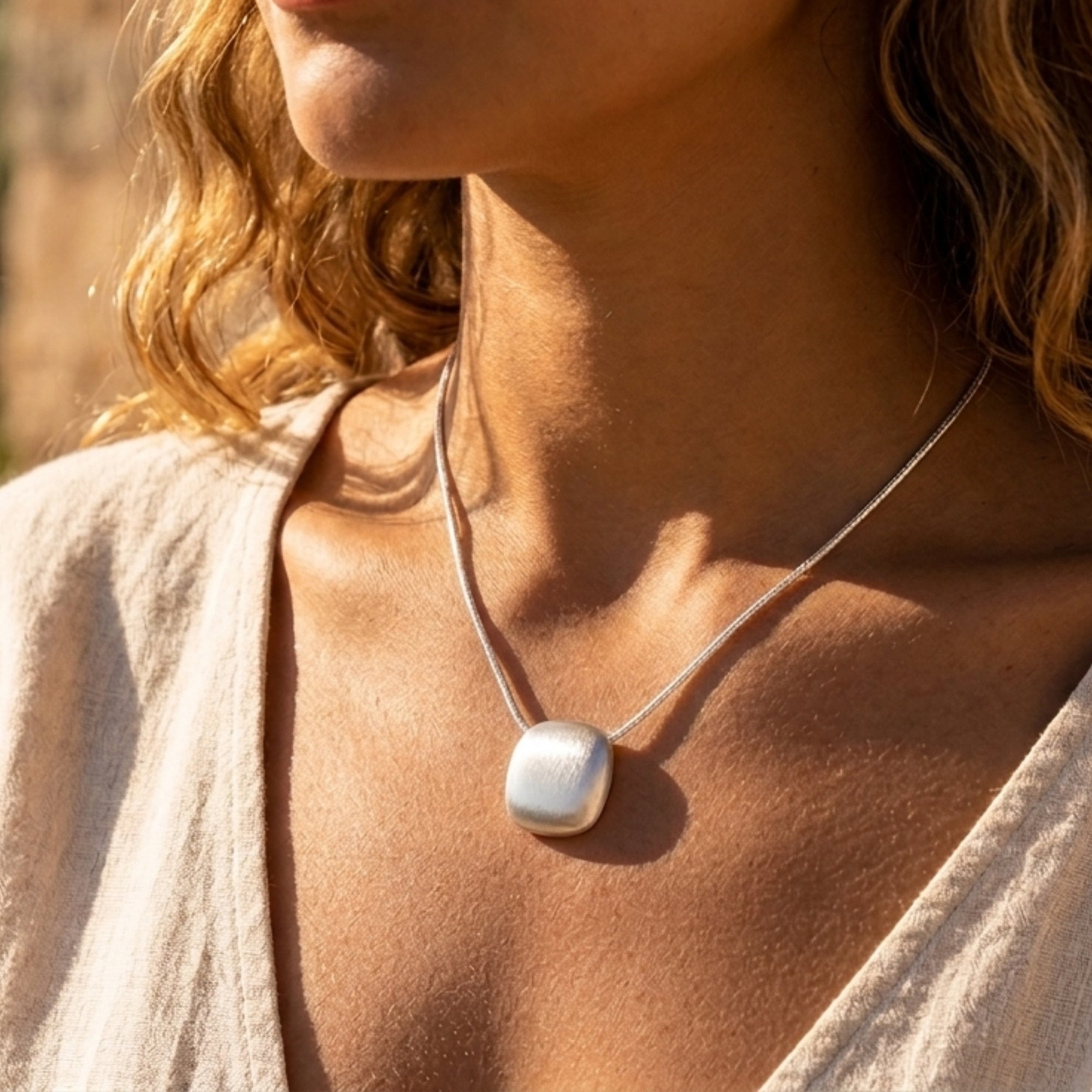Editorial portrait of woman wearing brushed 925 silver sphere pendant necklace by VAHN Jewels