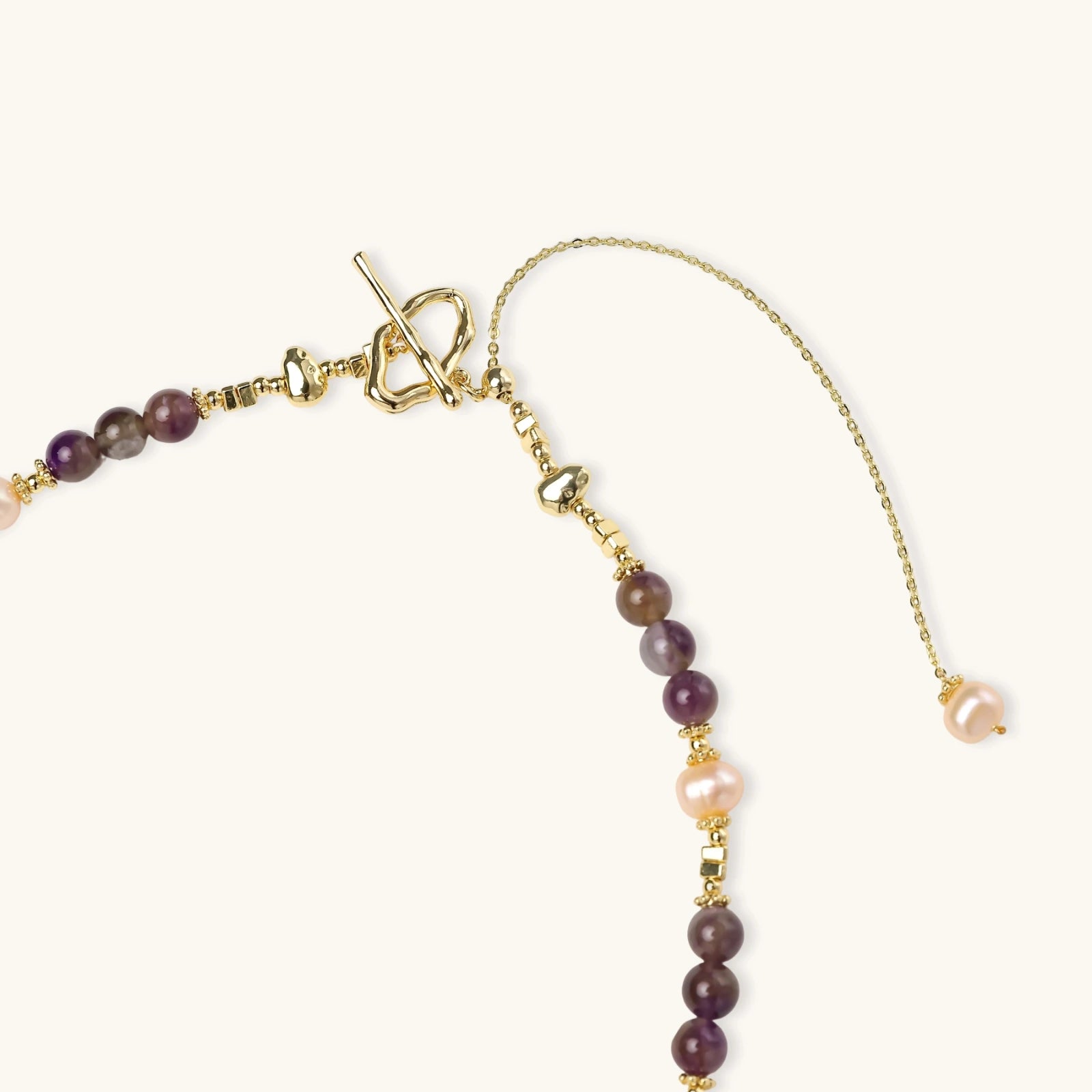 Detail of baroque freshwater pearl and amethyst beads on celestial pendant necklace