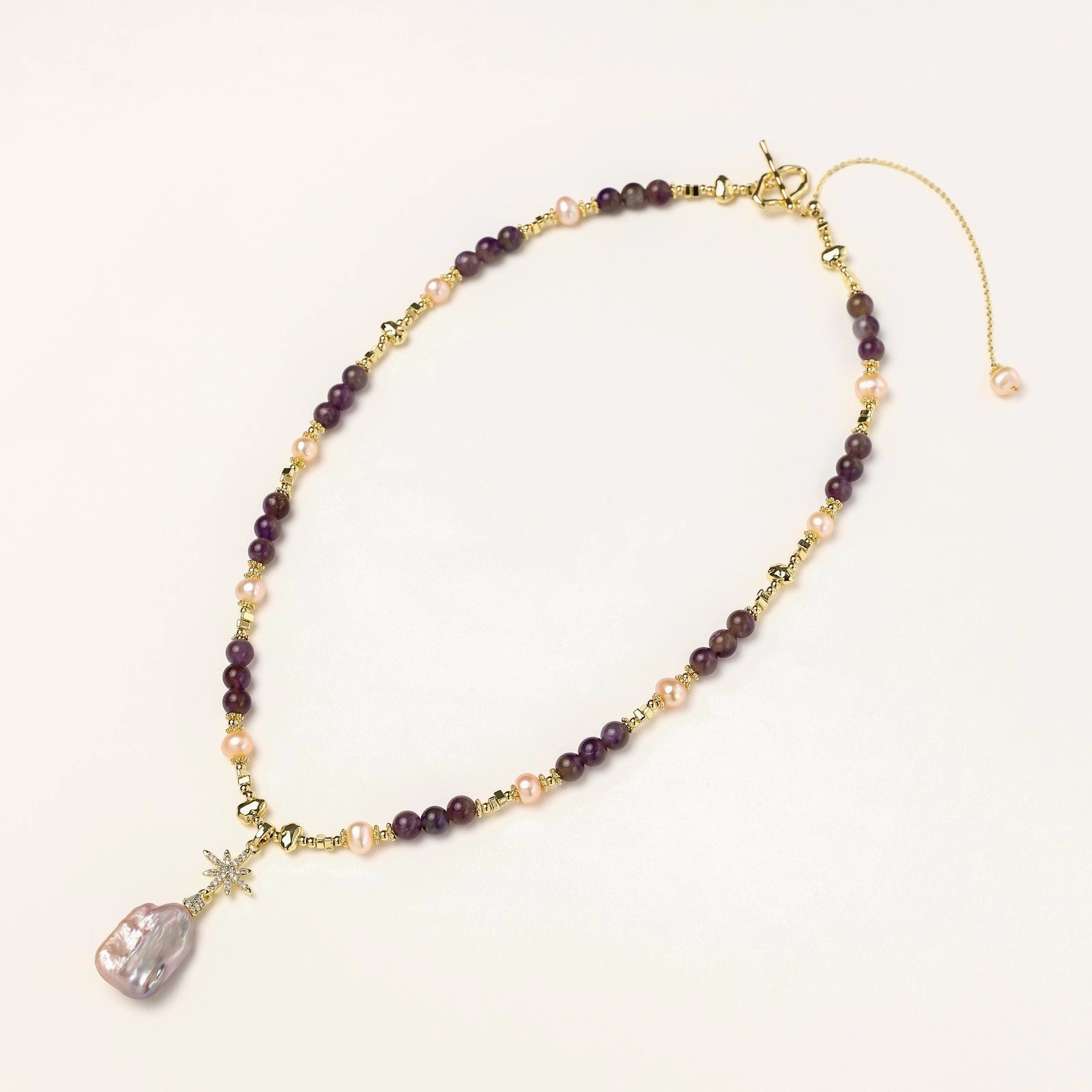 Flat lay of celestial amethyst baroque pearl necklace with genuine amethyst and freshwater pearls