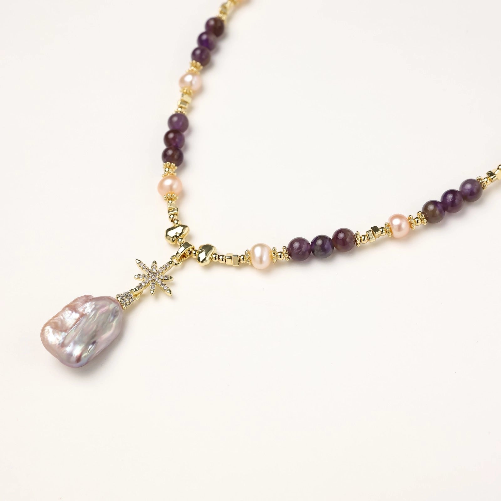  Close-up of pave star pendant with baroque freshwater pearl and amethyst beads in 14K gold