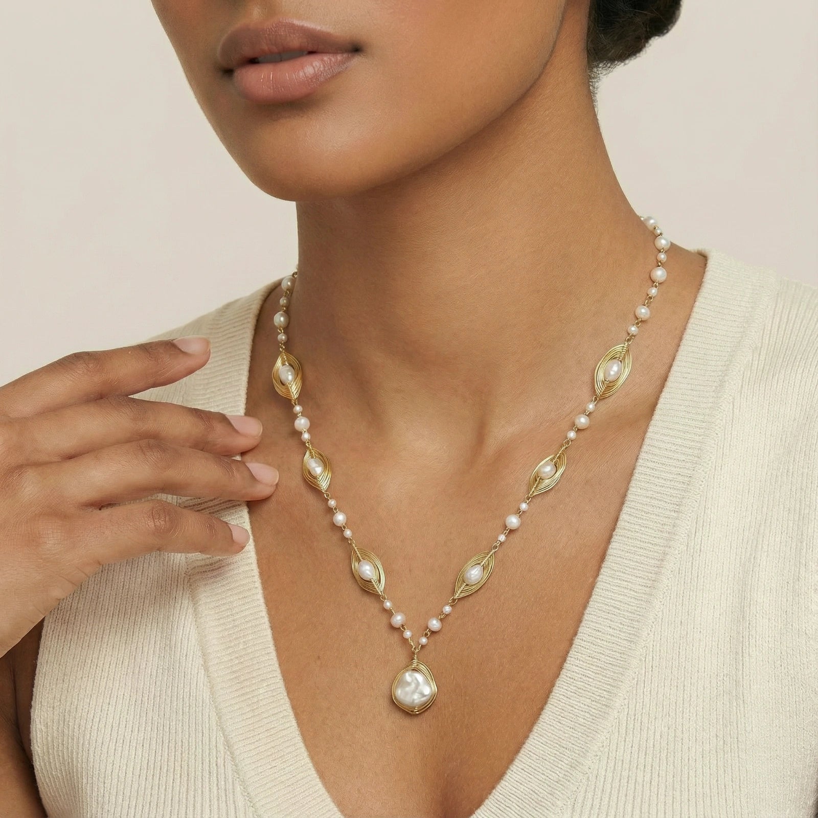 Close-up of woman wearing golden cage baroque pearl sautoir in 14K gold plated eco-brass by VAHN Jewels