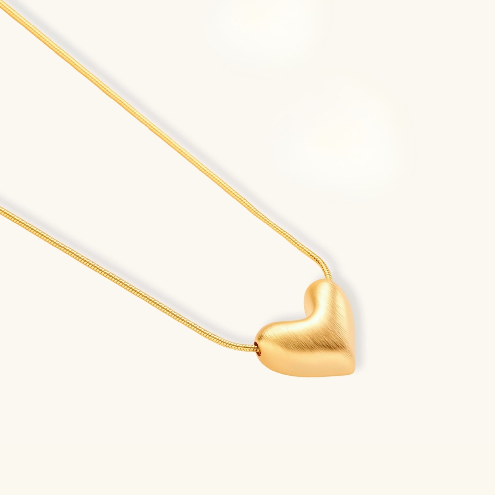 Close-up of brushed sculpted gold heart pendant in 18K gold-plated 925 sterling silver by VAHN Jewels