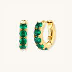 Standing view of green pave gold huggie hoop earrings showing emerald-green zirconia setting by VAHN Jewels