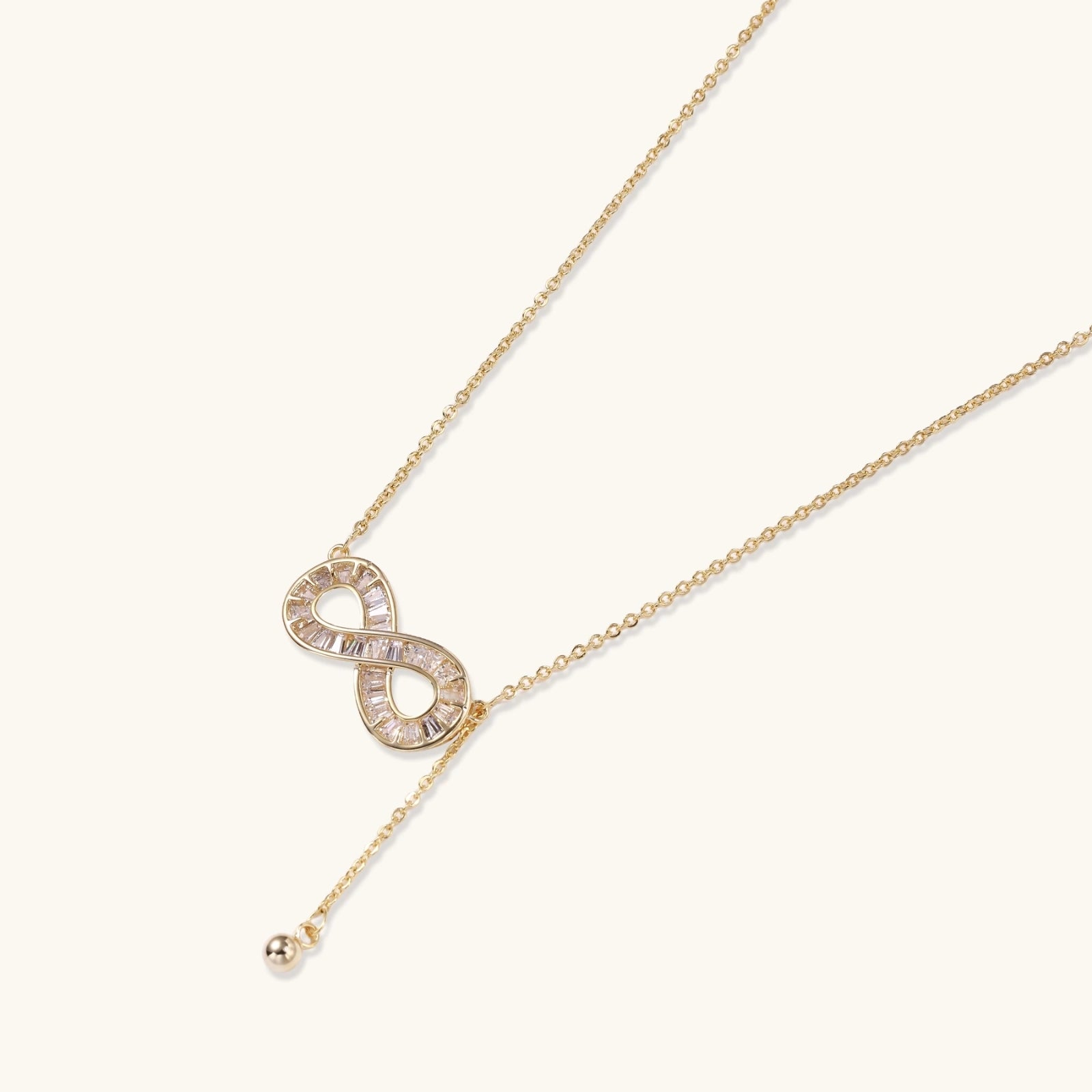 Close up of infinity pendant with baguette crystals on gold chain VAHN Jewels