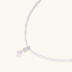 Close-up of geometric pearl drop pendant on lavender crystal and freshwater pearl necklace by VAHN Jewels