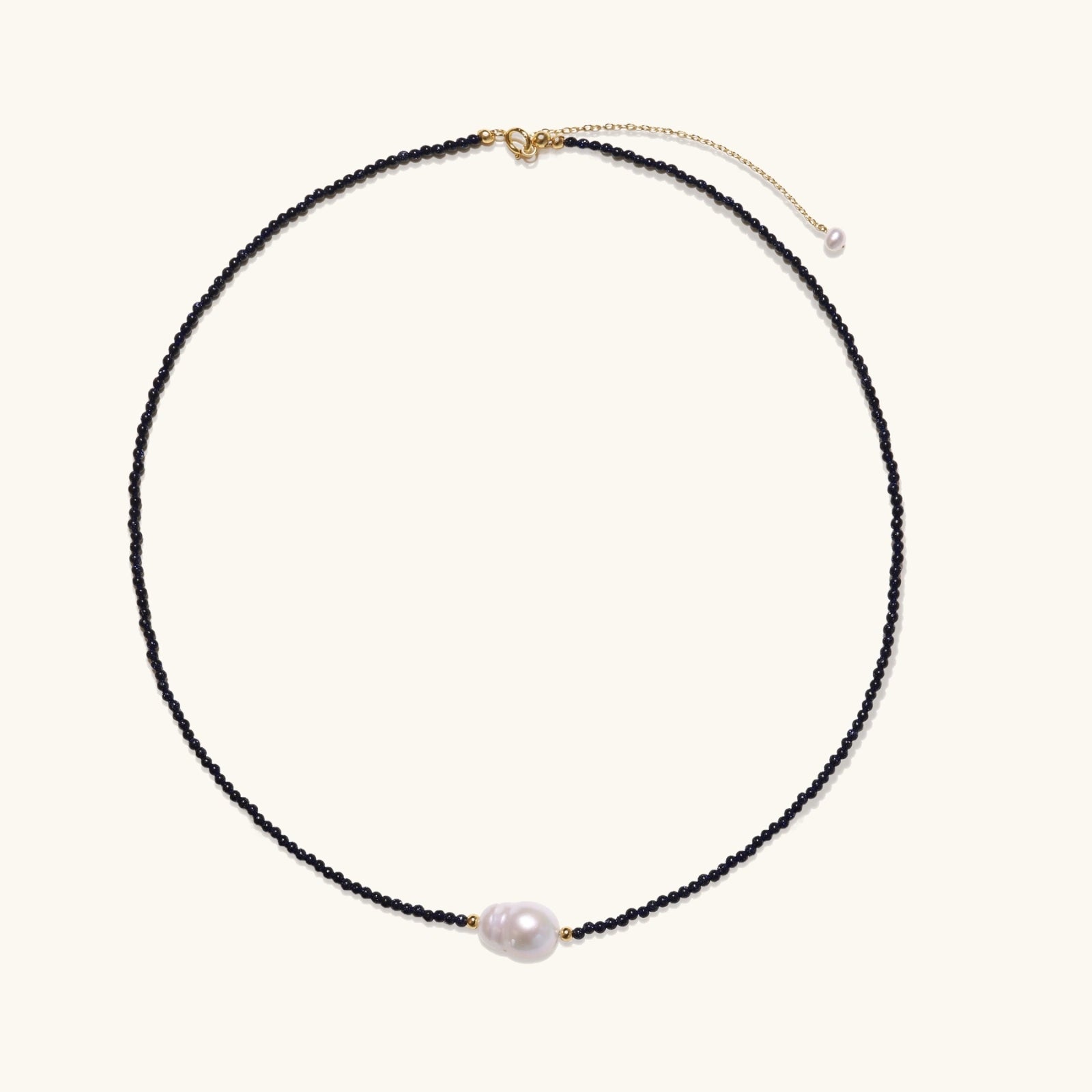 Flat lay of midnight pearl gold vermeil necklace in 18K vermeil with blue sandstone and baroque pearl