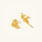 Close-up of asymmetrical gold textured stud earrings with freshwater pearl in 925 sterling silver