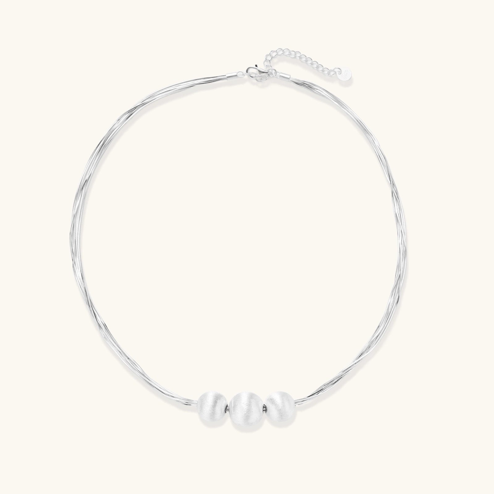 Flat lay of brushed silver multi-strand necklace with three silver beads in sterling silver 925