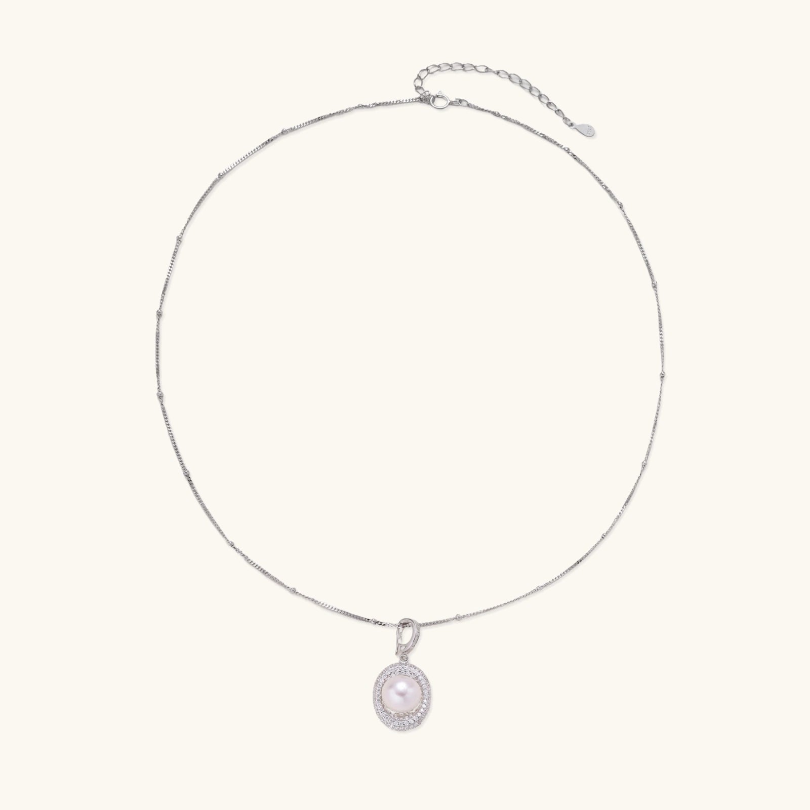 Flat lay of pearl halo silver necklace in rhodium plated sterling silver 925 with satellite chain
