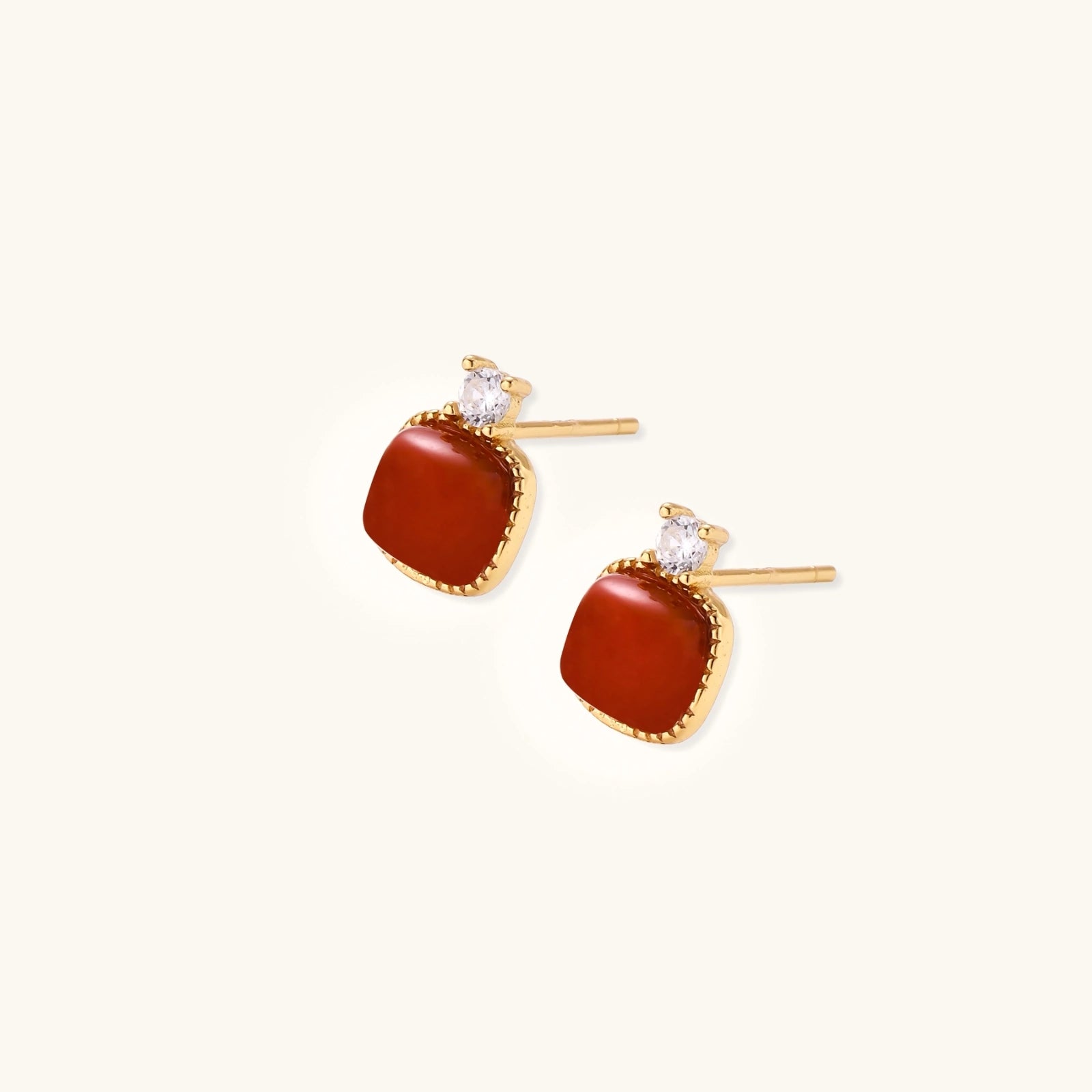 Close-up of cushion-cut red agate studs with cubic zirconia in gold vermeil setting
