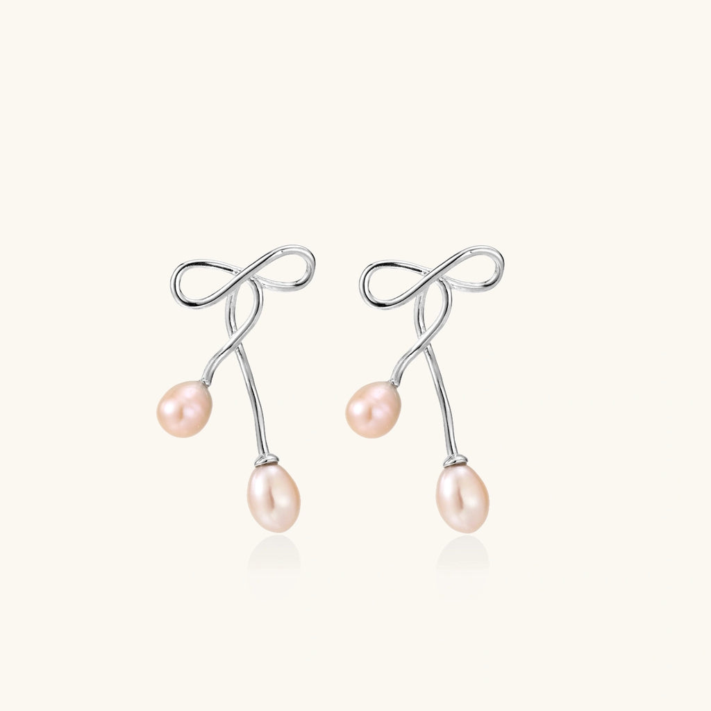 Silver bow pearl drop earrings in rhodium-plated 925 sterling silver with double blush freshwater pearl drops by VAHN Jewels
