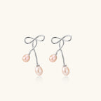 Silver bow pearl drop earrings in rhodium-plated 925 sterling silver with double blush freshwater pearl drops by VAHN Jewels