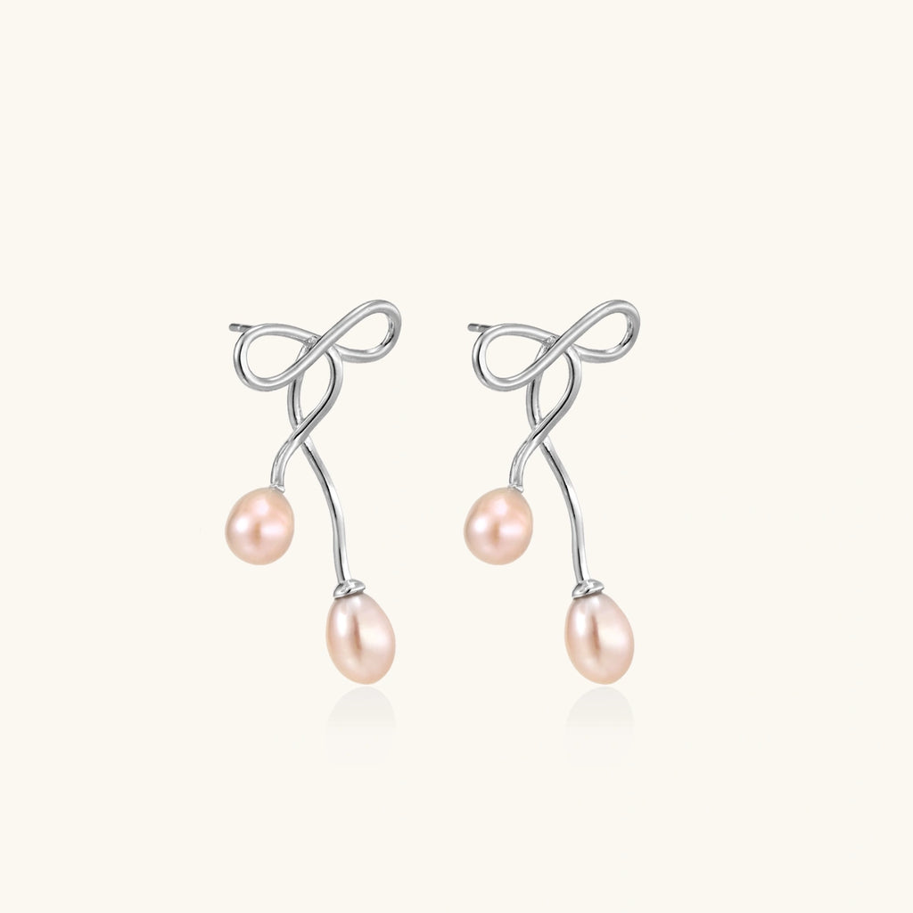 Pair view of silver bow pearl drop earrings showing sculptural bow and double pearl drops by VAHN Jewelsbackground