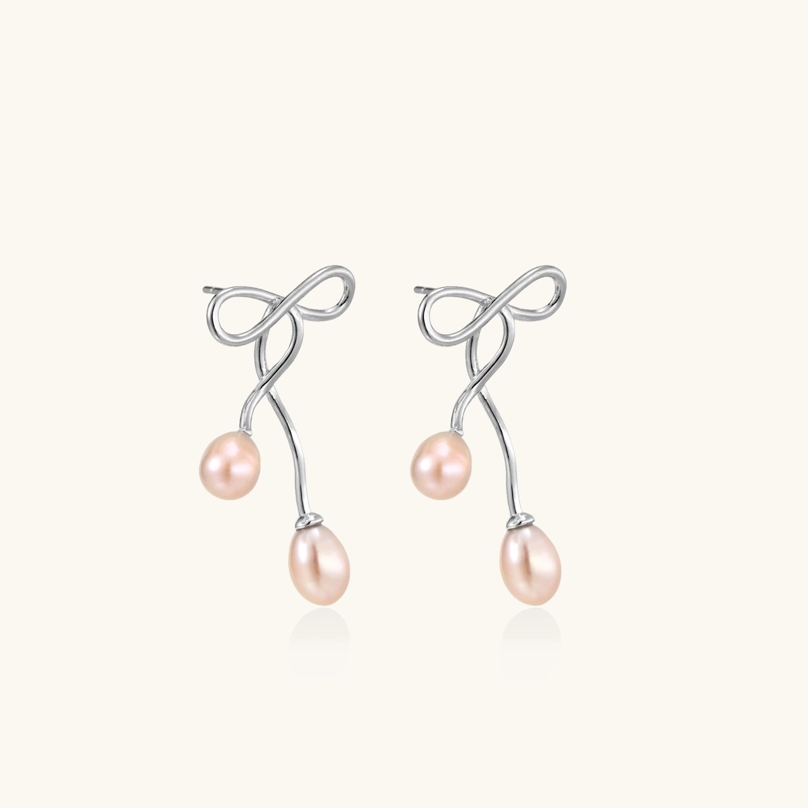 Pair view of silver bow pearl drop earrings showing sculptural bow and double pearl drops by VAHN Jewelsbackground