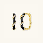 Close-up of striped black enamel and gold hoop earrings with pave cubic zirconia in 925 sterling silver