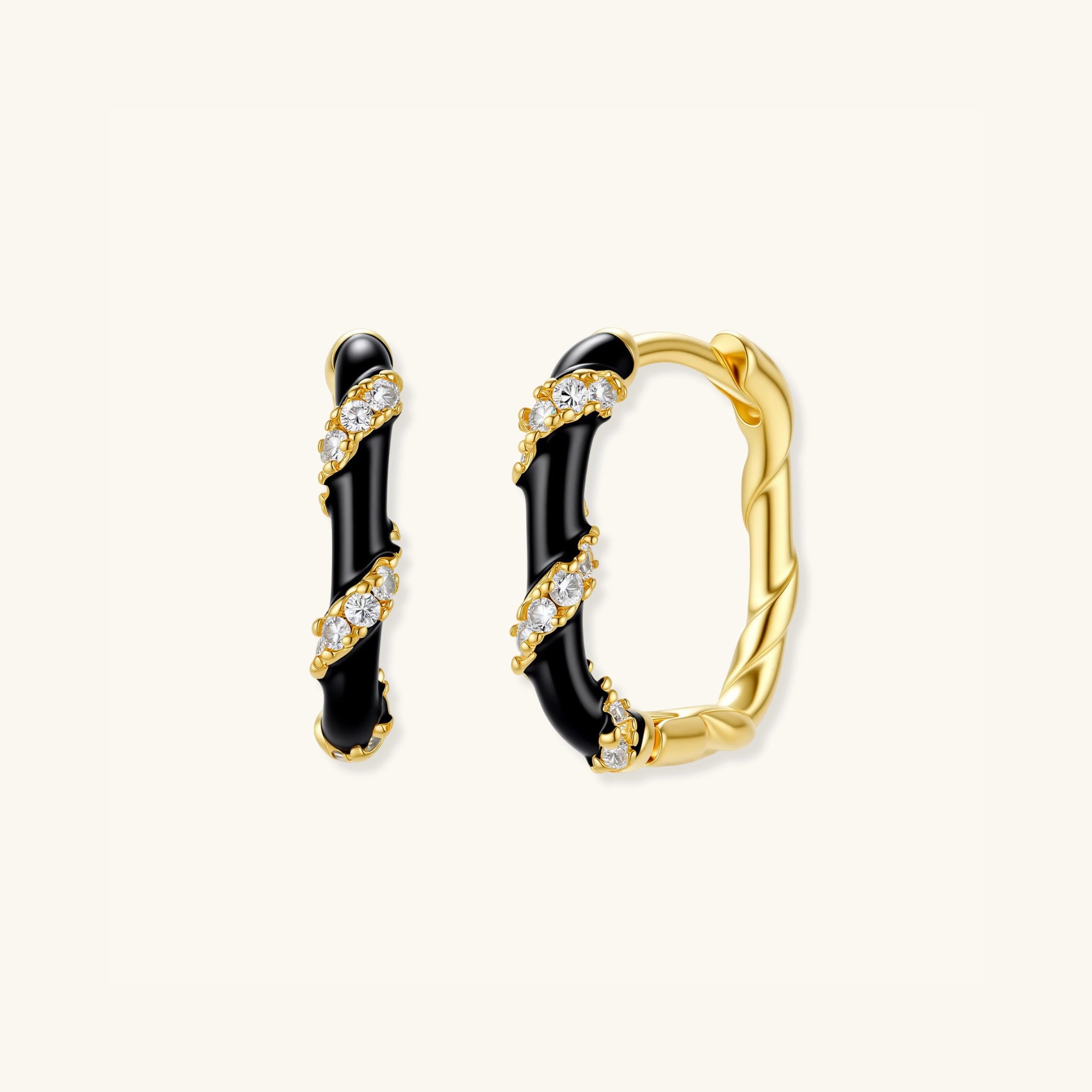 Close-up of striped black enamel and gold hoop earrings with pave cubic zirconia in 925 sterling silver