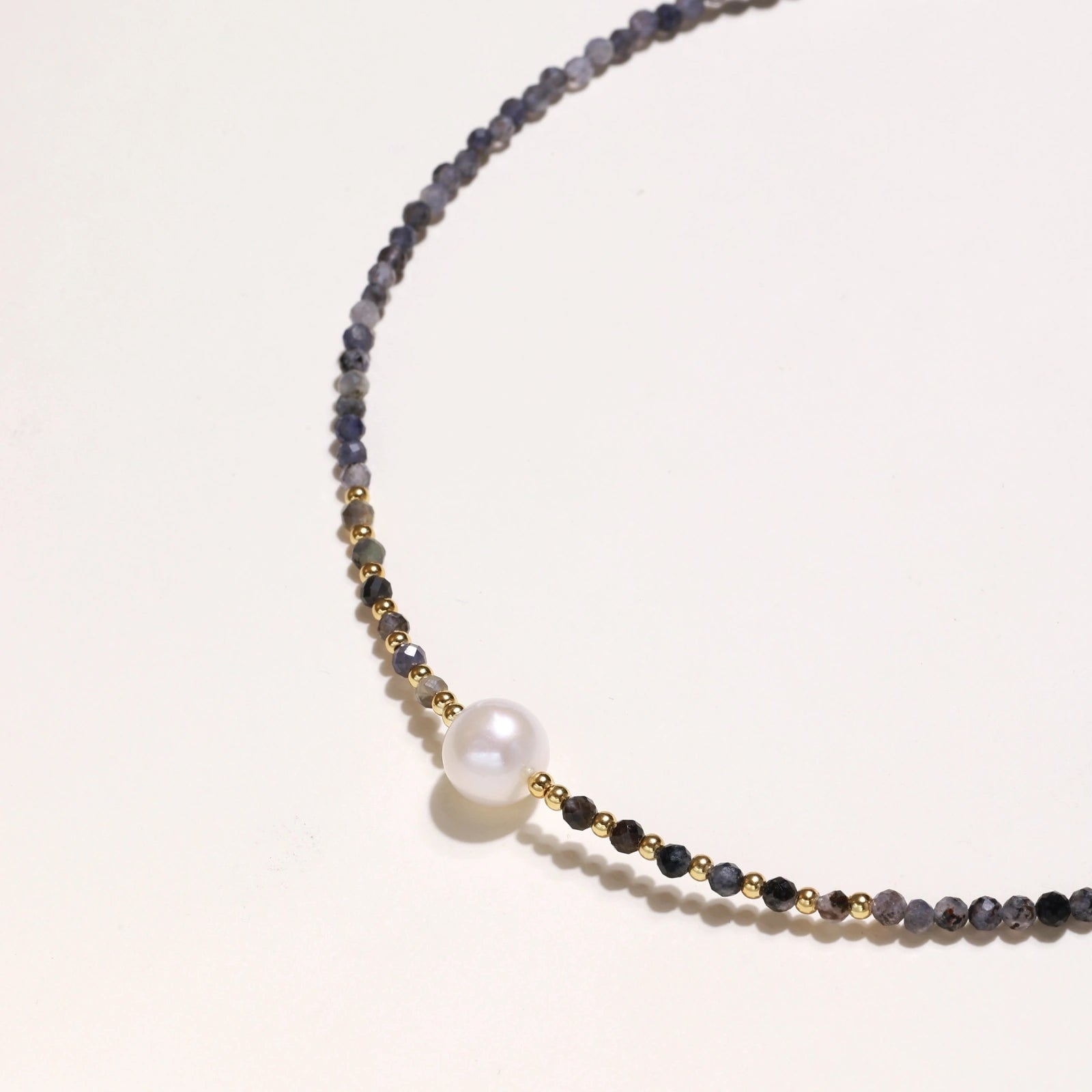 Detail view of faceted iolite beads and gold vermeil accents on twilight pearl necklace by VAHN Jewels
