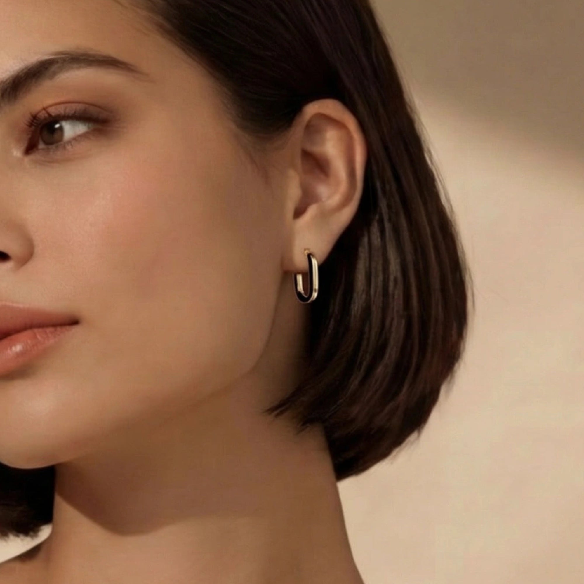 Woman wearing black enamel gold hoop earrings in 14K gold-plated 925 sterling silver by VAHN Jewels