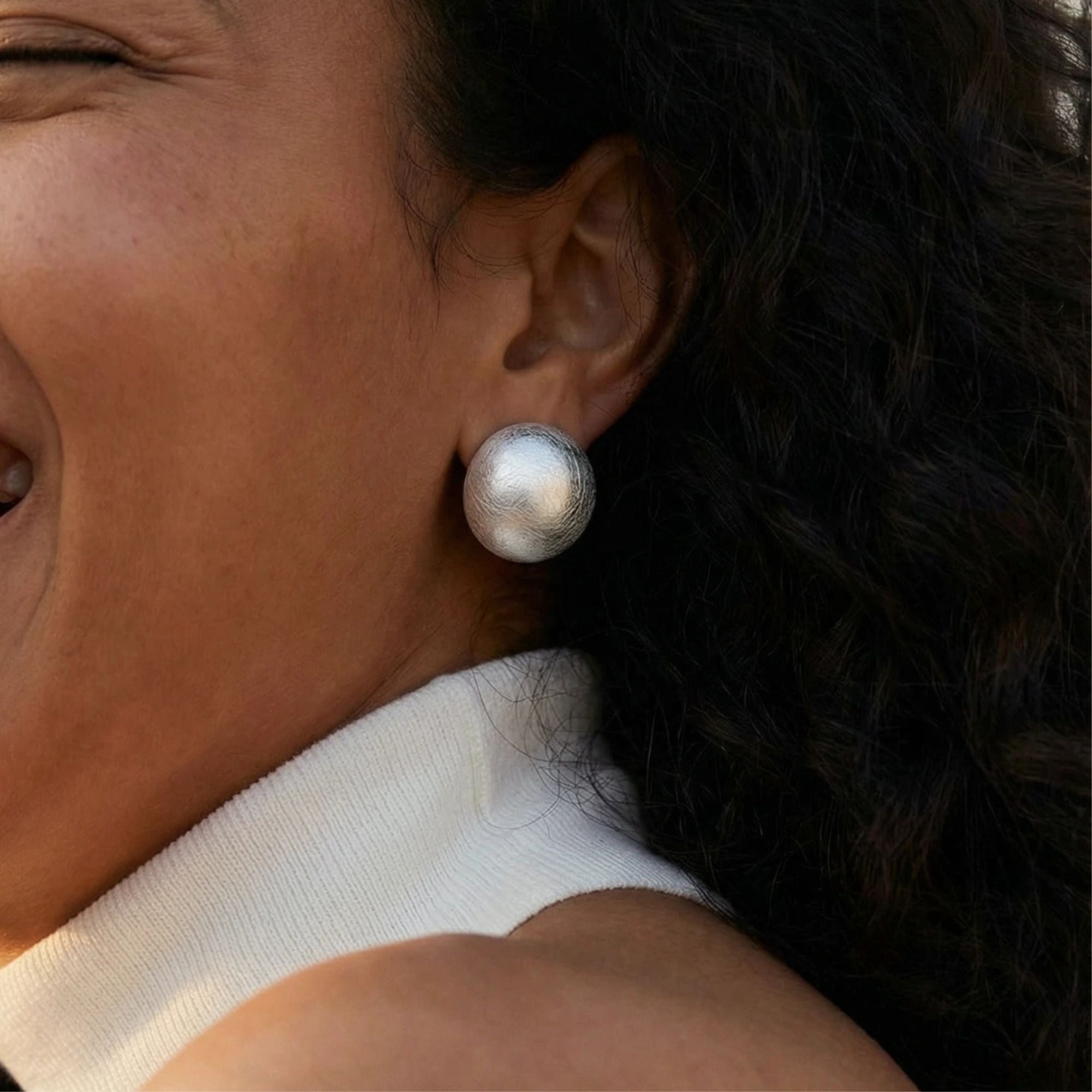 Woman wearing brushed silver dome clip-on earrings in 925 sterling silver by VAHN Jewels