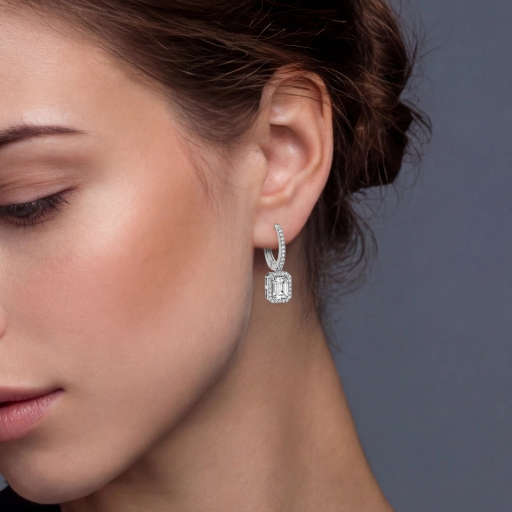 Woman wearing emerald cut moissanite drop earrings in 925 sterling silver by VAHN Jewels