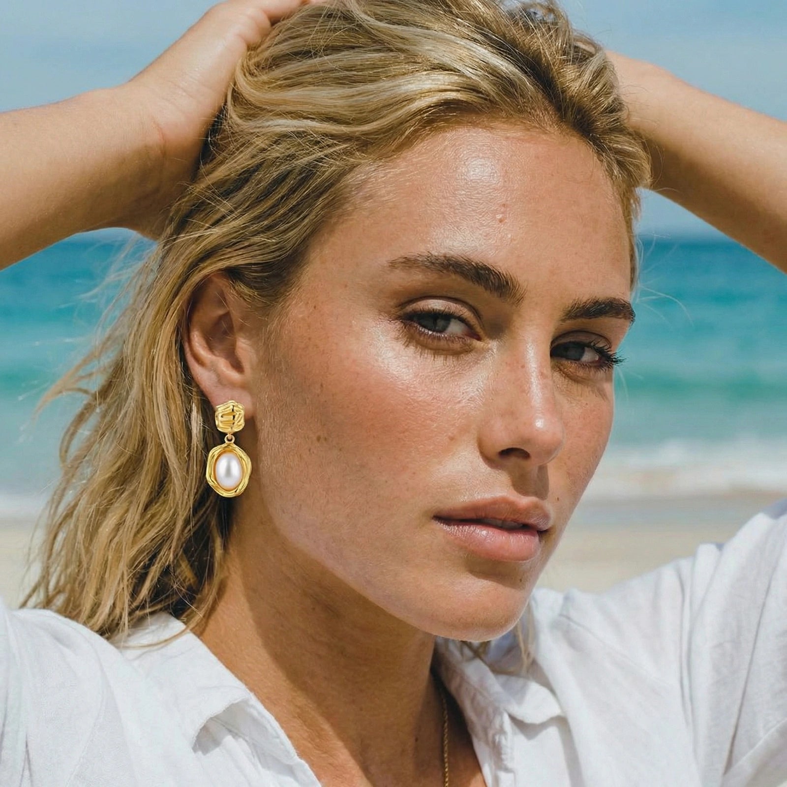 Woman wearing golden bloom pearl drop earrings in 18K gold-plated 925 sterling silver by VAHN Jewels