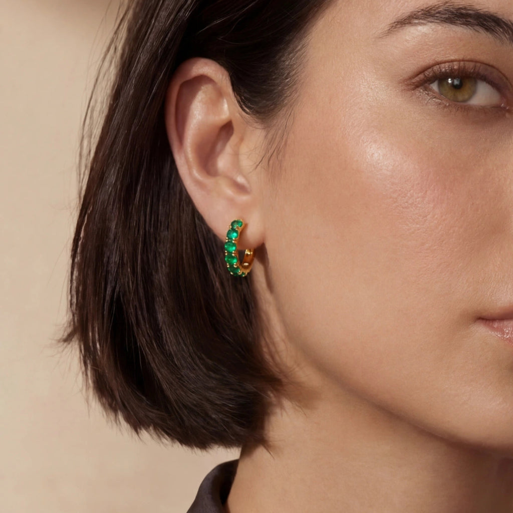 Woman wearing green pave gold huggie hoop earrings in 18K gold-plated 925 sterling silver by VAHN Jewels
