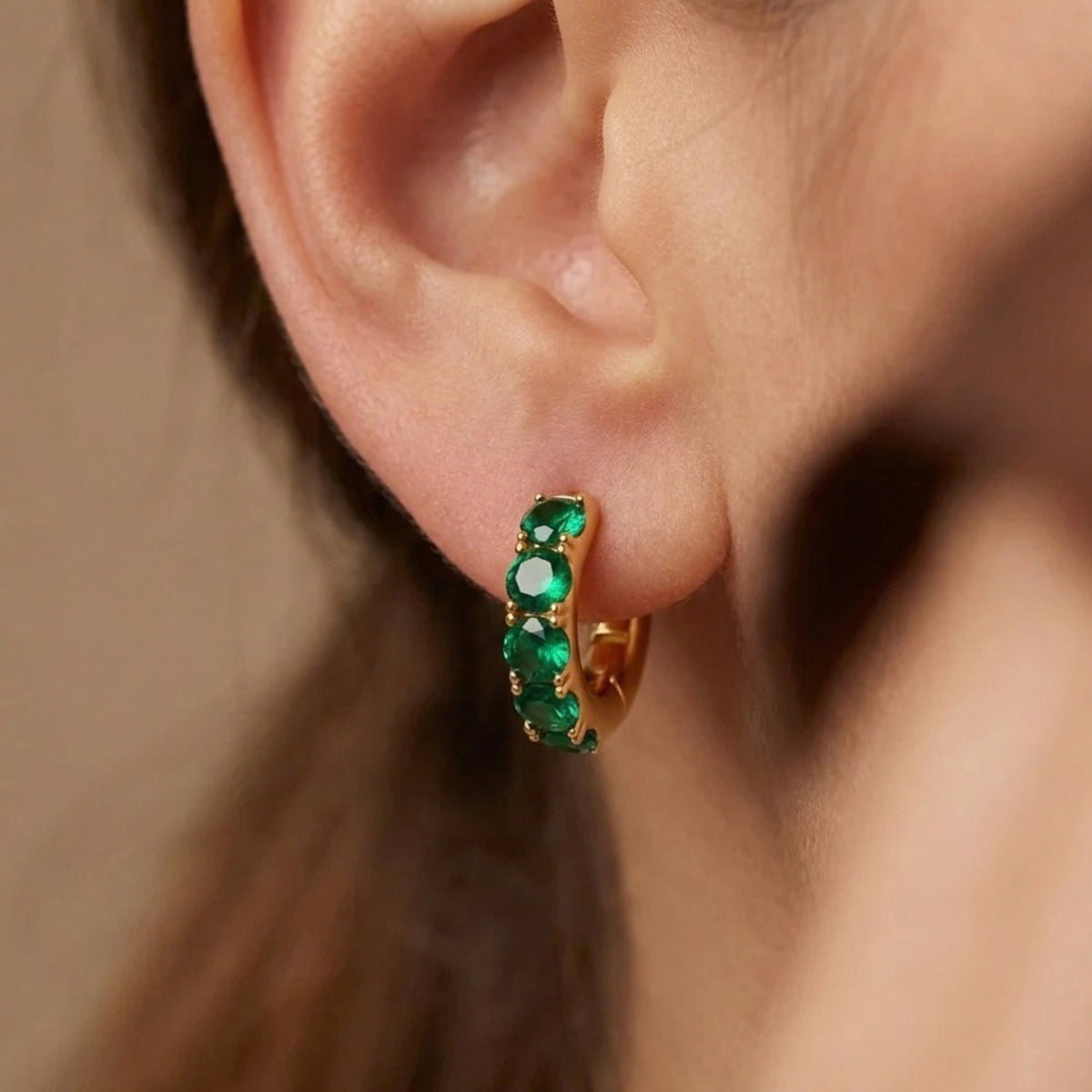 Woman wearing green pave gold huggie hoop earrings in 18K gold-plated 925 sterling silver by VAHN Jewels