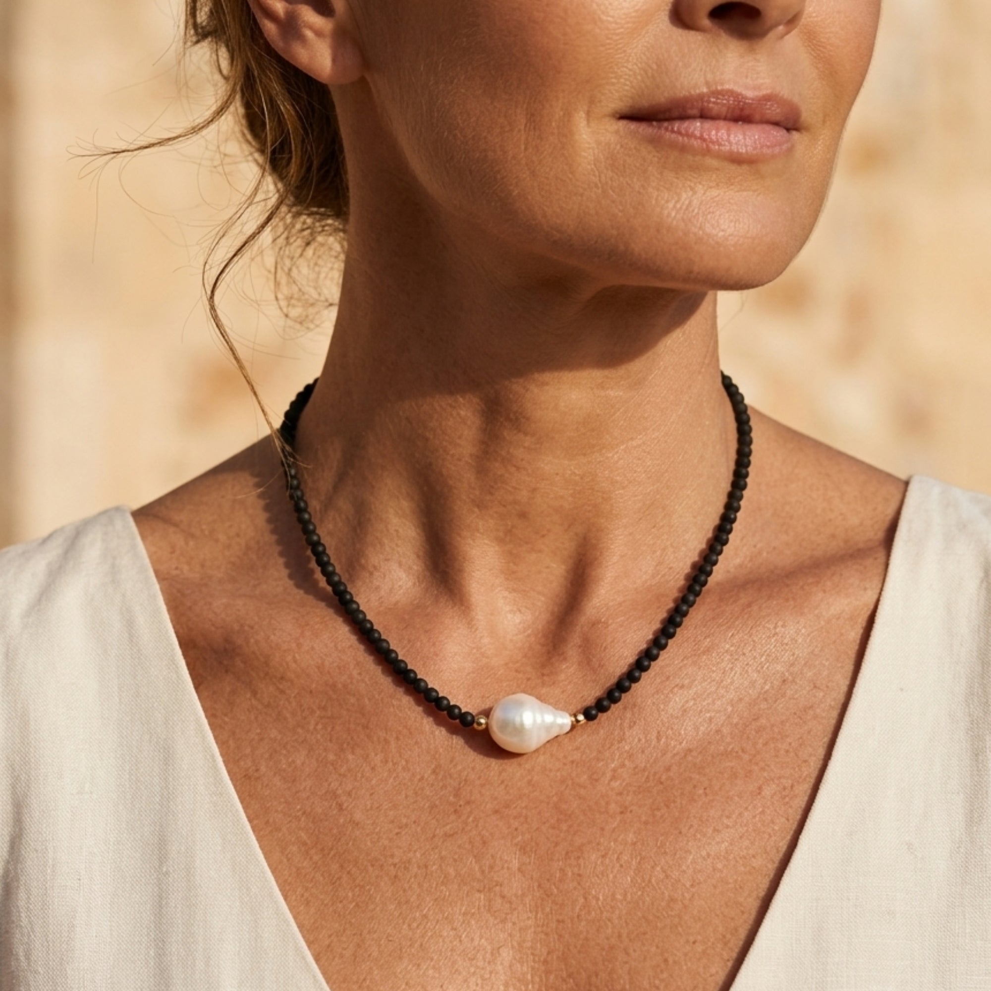 Woman wearing Midnight baroque pearl necklace with blue sandstone beads and 18K gold vermeil by VAHN Jewels