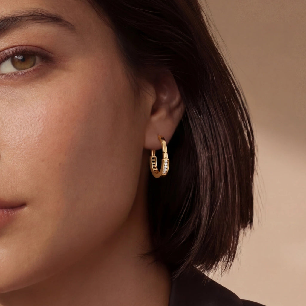 Woman wearing pave gold huggie hoop earrings in 14K gold-plated 925 sterling silver by VAHN Jewels