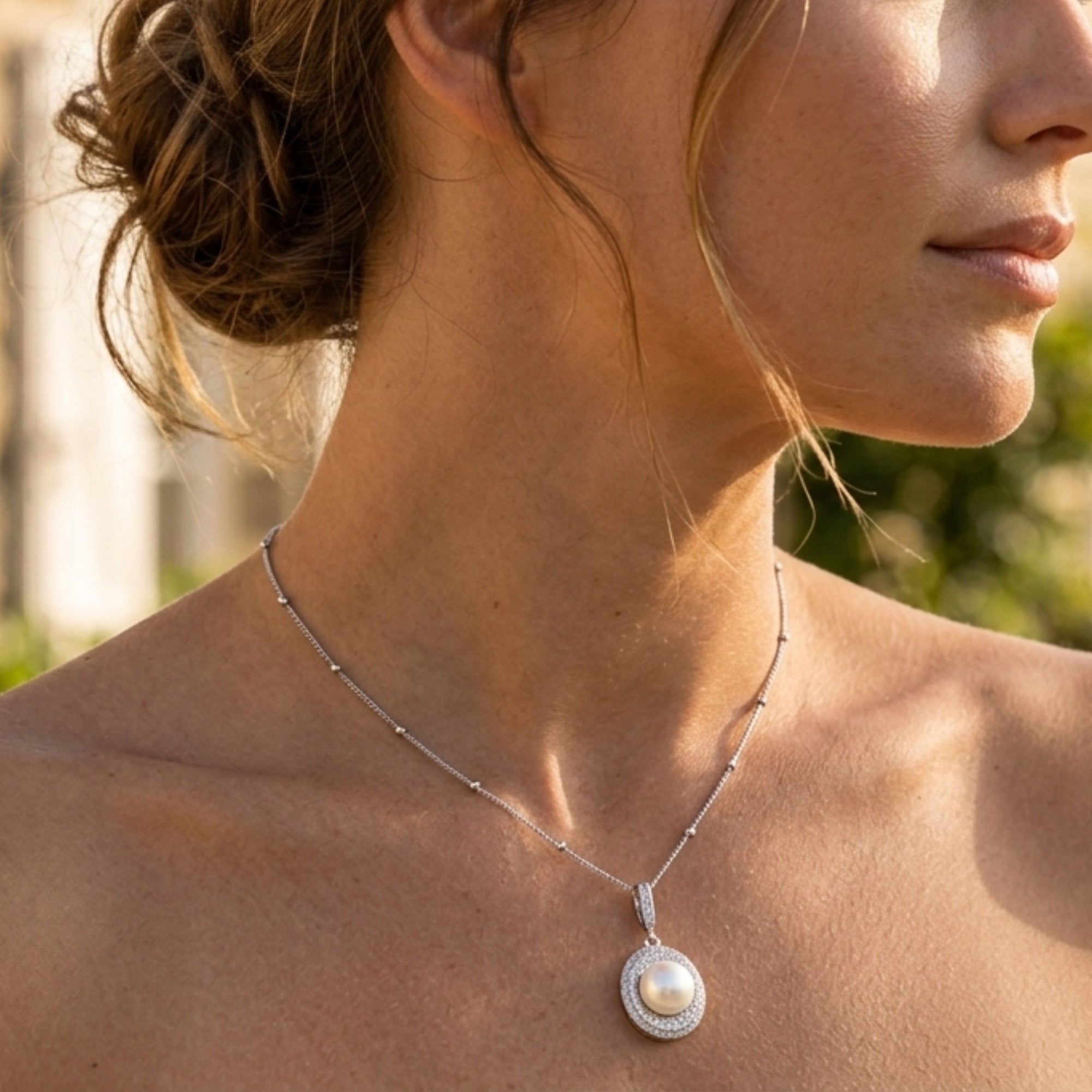 Woman wearing pearl halo pendant necklace in rhodium-plated 925 sterling silver by VAHN Jewels