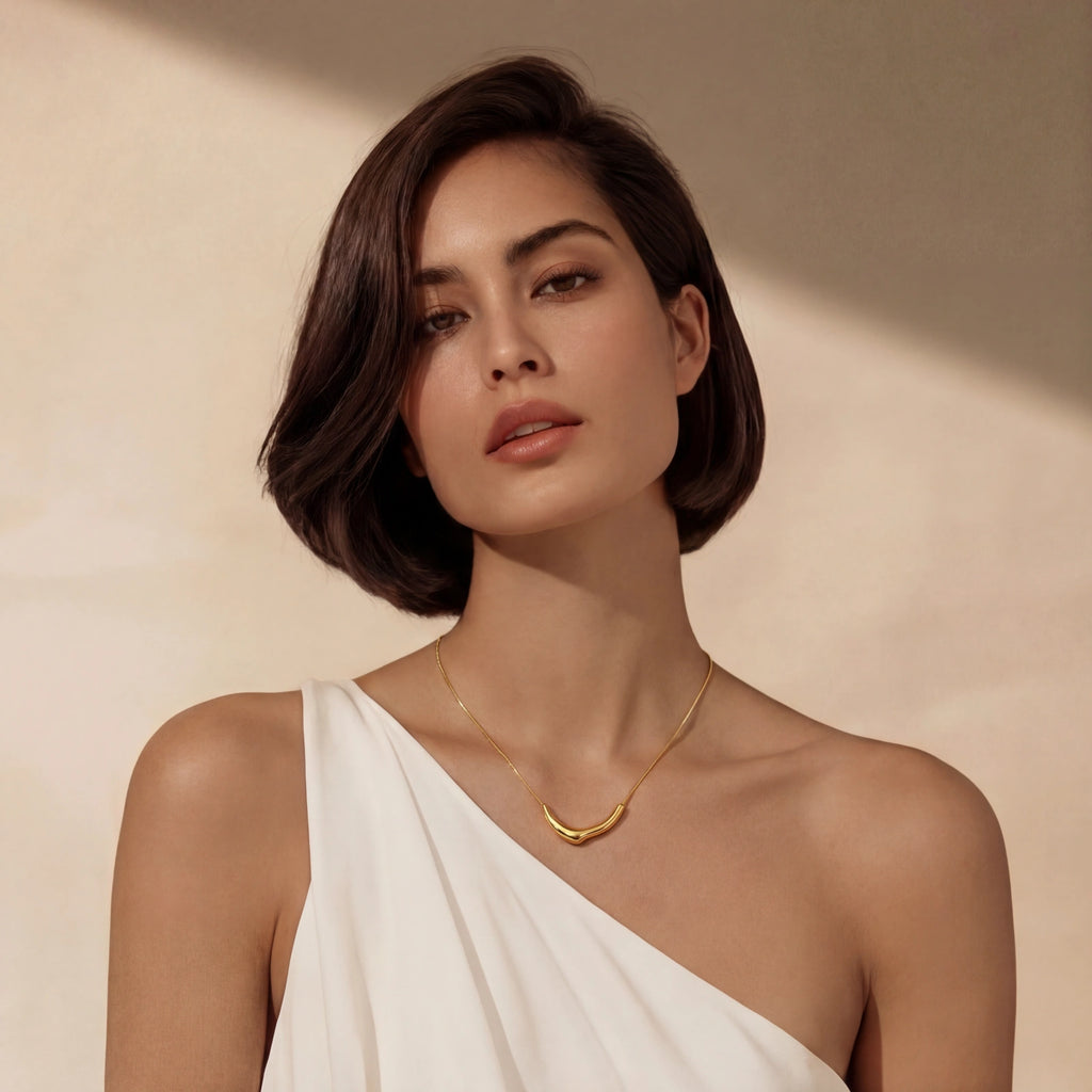 Woman wearing sleek curve pendant gold necklace in 18K gold-plated 925 sterling silver by VAHN Jewels

