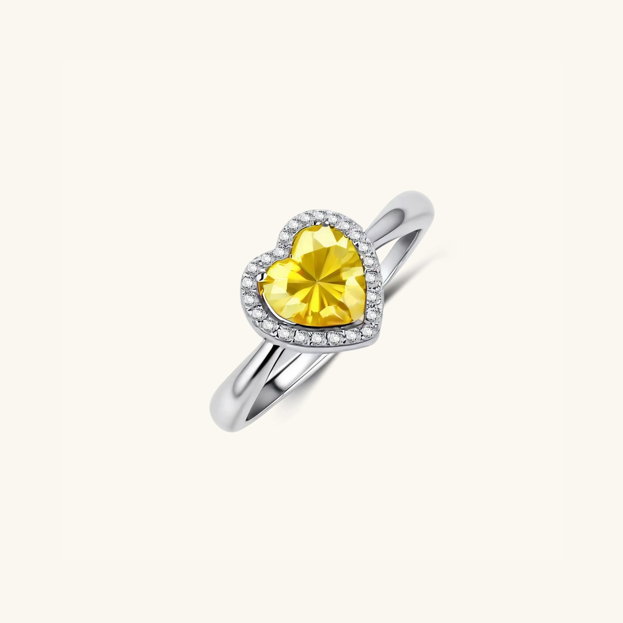 Close-up of heart-cut yellow moissanite with white pave halo in 925 sterling silver ring