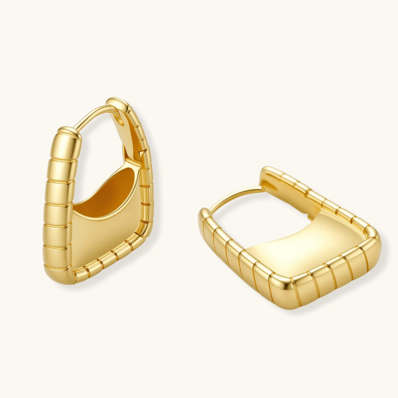 Close-up of spiral bamboo ridge detail on 18K gold huggie hoop earrings
