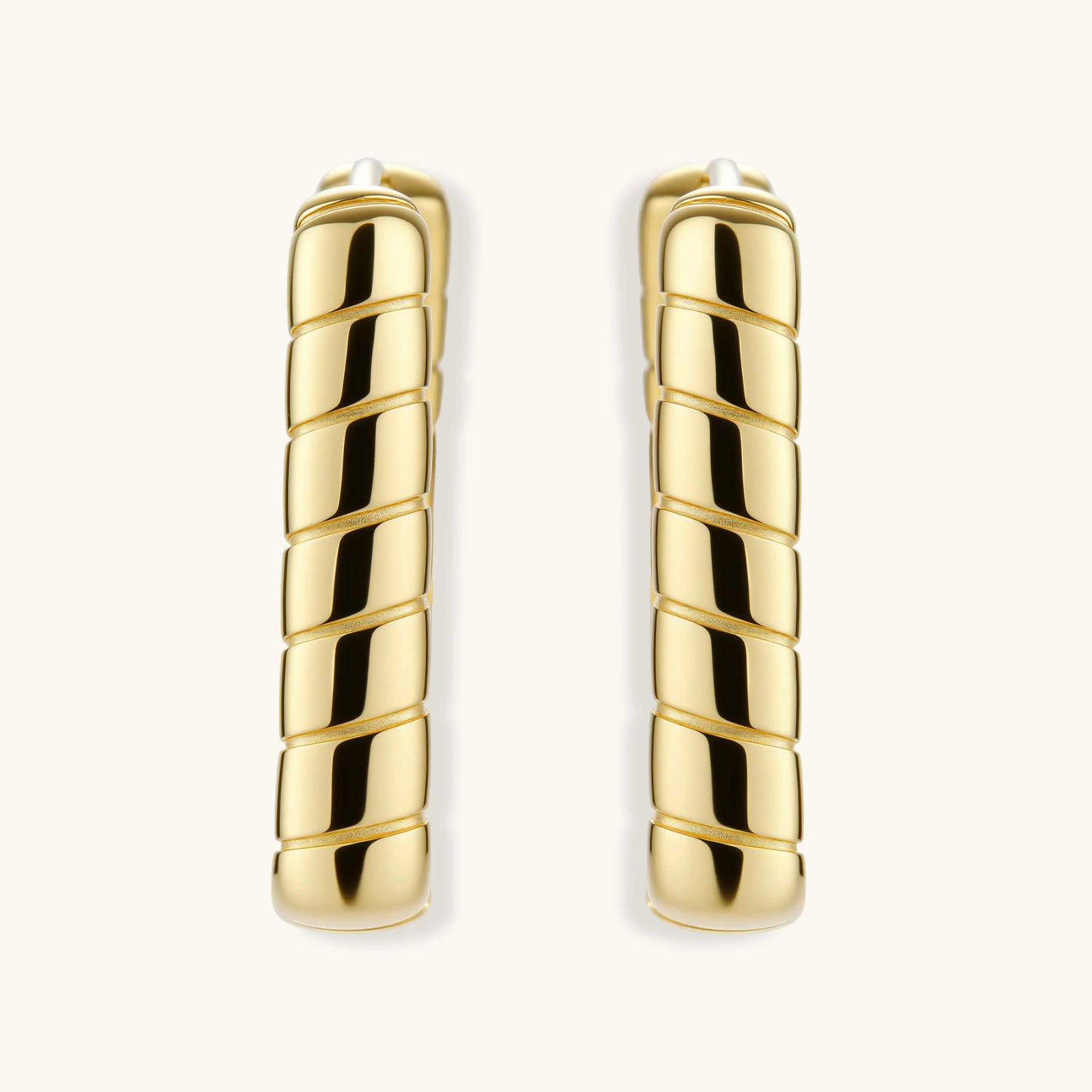 Side view of sculptural bamboo segment huggie hoop earrings in gold