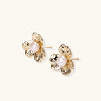 Close-up of freshwater pearl nestled in textured gold bloom stud earring