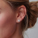 Woman wearing celestial star stud earrings — brilliant moissanite jewelry