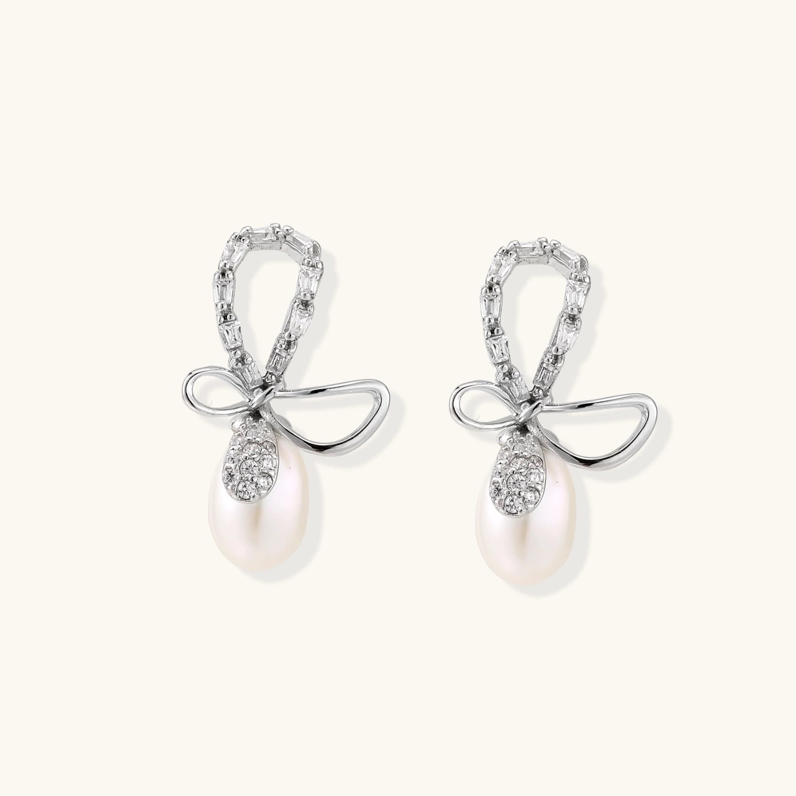Close-up of rhodium-plated 925 silver bow earrings with pearl drop