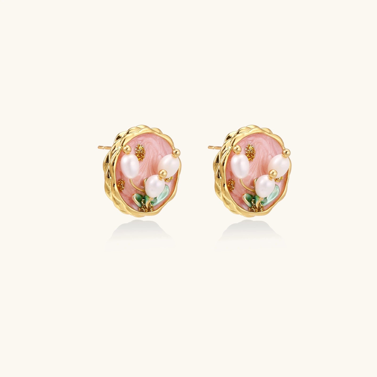 Close-up of hand-painted pink enamel garden pearl stud earrings