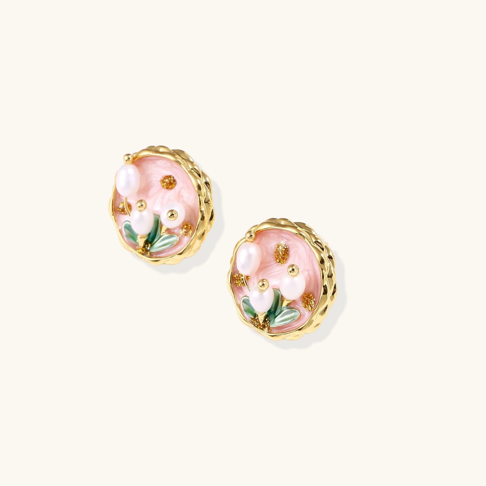Detail of three freshwater pearls on gold garden stud earrings with enamel
