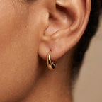 Small gold teardrop huggie earring worn on the ear | VAHN Jewels