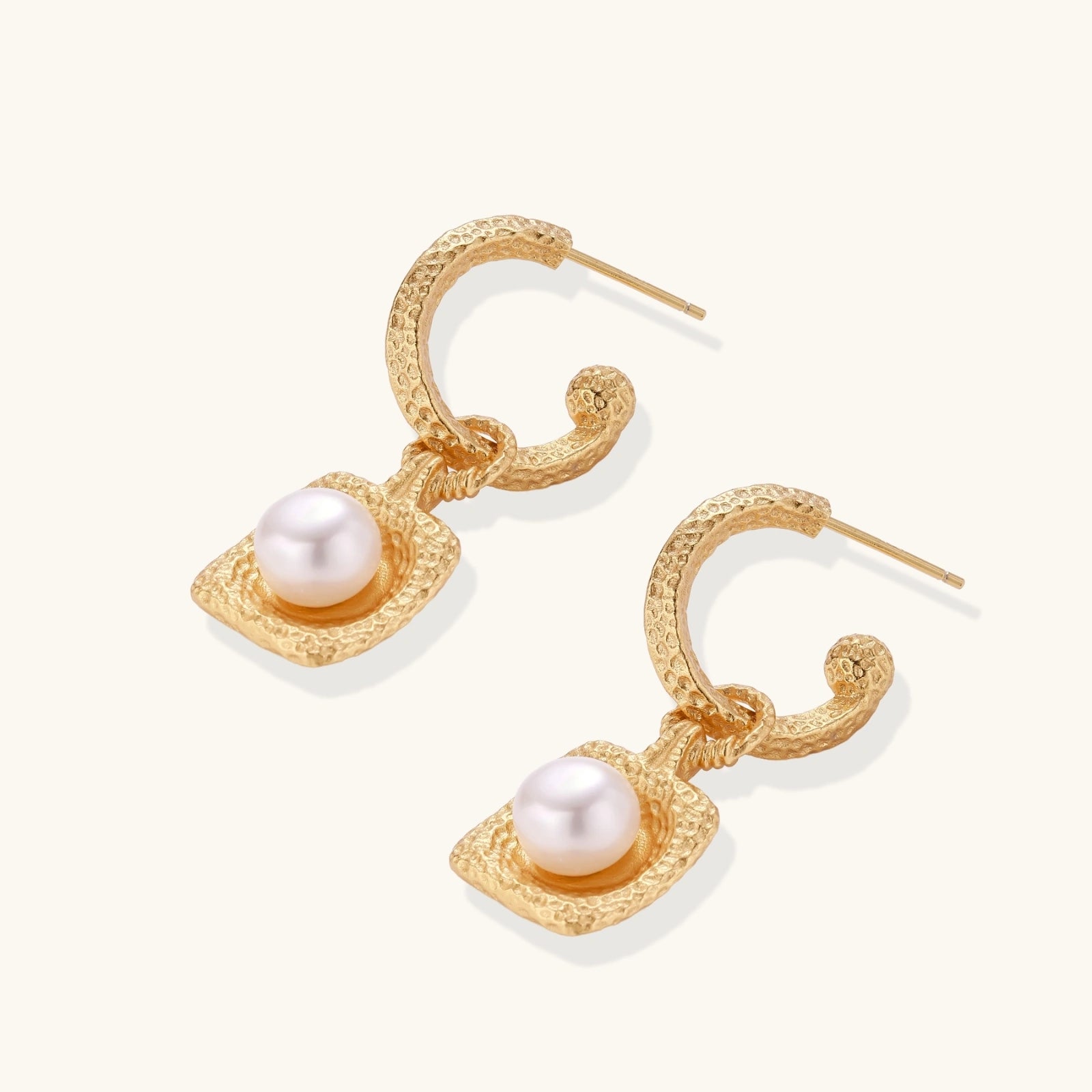 Close-up of hammered 24K gold vermeil hoop and cushion pearl on drop earrings
