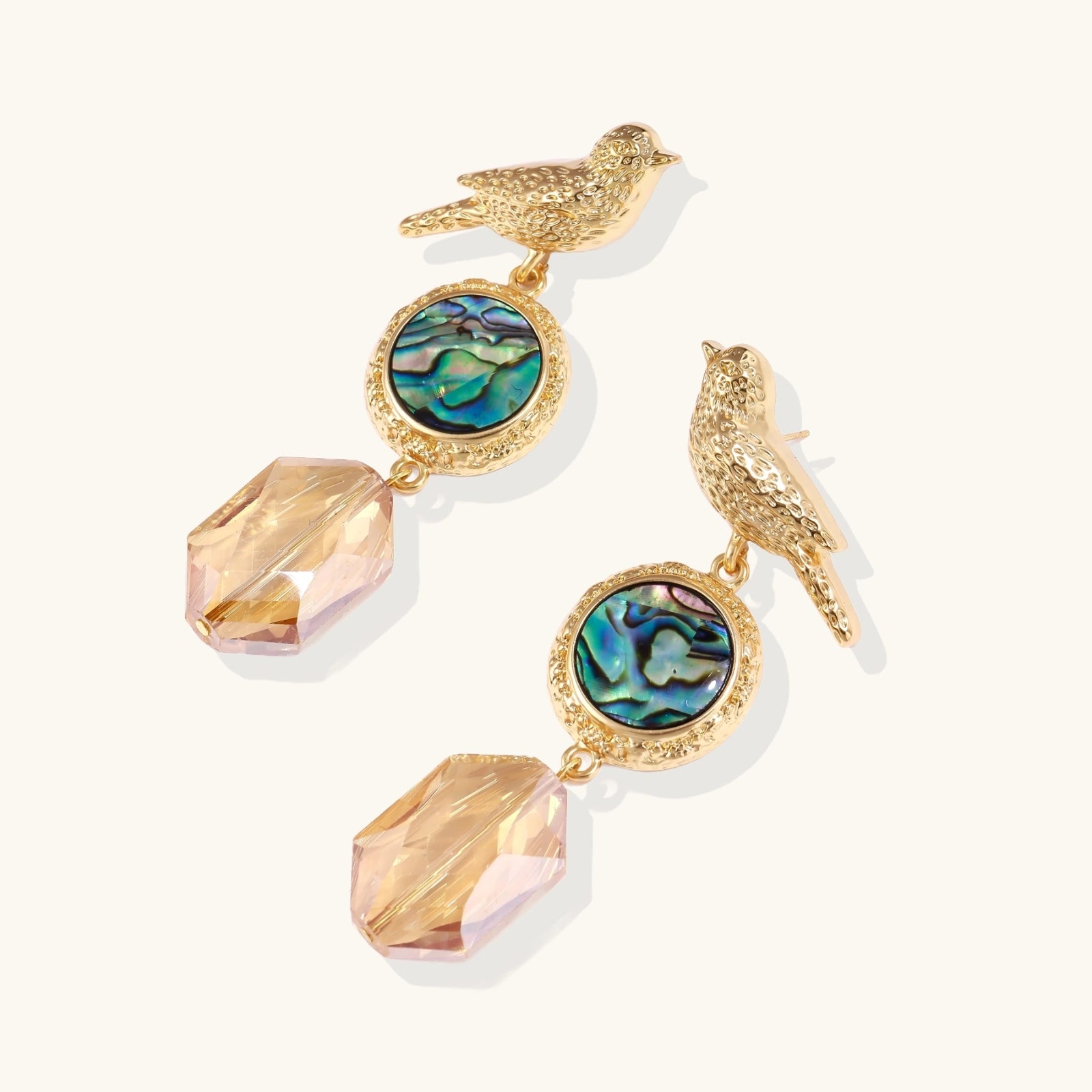 Close-up of iridescent abalone shell and champagne crystal on songbird earrings